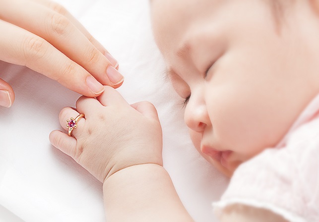 ベビー　すやすや眠っている赤ちゃんとお母さんの手